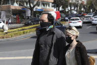 People wearing masks to help protect against the spread of coronavirus, walk before a nationwide lockdown, in Ankara, Turkey, Wednesday, April 21, 2021. Turkey continued to post record-high daily COVID-19 deaths on Wednesday, with 362 fatalities registered in the last 24 hours, Health Ministry data showed. The country, which now ranks among the worst-hit nations, also reported 61,967 new confirmed cases.(AP Photo/Burhan Ozbilici)