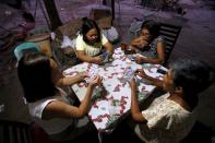 Women play a Russian poker card game in Angeles city, north of Manila, Philippines, March 6, 2015. When paying your final respects for a relative or friend, the last thing you might expect to see at the wake is people placing bets on a card game or bingo. Not in the Philippines. Filipinos, like many Asians, love their gambling. But making wagers on games such as "sakla", the local version of Spanish tarot cards, is particularly common at wakes because the family of the deceased gets a share of the winnings to help cover funeral expenses. Authorities have sought to regulate betting but illegal games persist, with men and women, rich and poor, betting on anything from cockfighting to the Basque hard-rubber ball game of jai-alai, basketball to spider races. Many told Reuters photographer Erik De Castro that gambling is only an entertaining diversion in a country where two-fifths of the population live on $2 a day. But he found that some gamble every day. Casino security personnel told of customers begging to be banned from the premises, while a financier who lends gamblers money at high interest described the dozens of vehicles and wads of land titles given as collateral by those hoping lady luck would bring them riches. REUTERS/Erik De Castro PICTURE 22 OF 29 FOR WIDER IMAGE STORY "HIGH STAKES IN MANILA". SEARCH "BINGO ERIK" FOR ALL IMAGES.