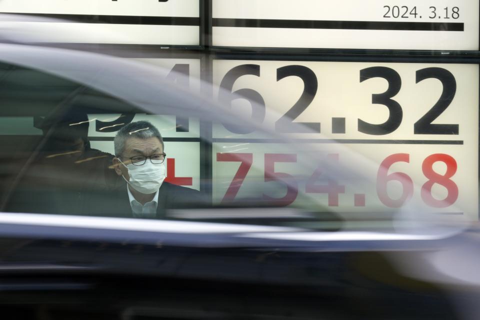 A person stands in front of an electronic stock board showing Japan's Nikkei 225 index at a securities firm Monday, March 18, 2024, in Tokyo. Asian stocks advanced Monday ahead of policy decisions this week by Japan’s central bank and the Federal Reserve. (AP Photo/Eugene Hoshiko)