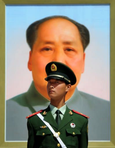 A Chinese policeman stands in front of a portrait of the late Chinese leader Mao Zedong at Baijing's Tiananmen Square in April 2012. The wife of Bo Xilai -- the former political leader whose downfall sent shockwaves through China -- has been charged with murdering a British businessman, according to the Xinhua news agency