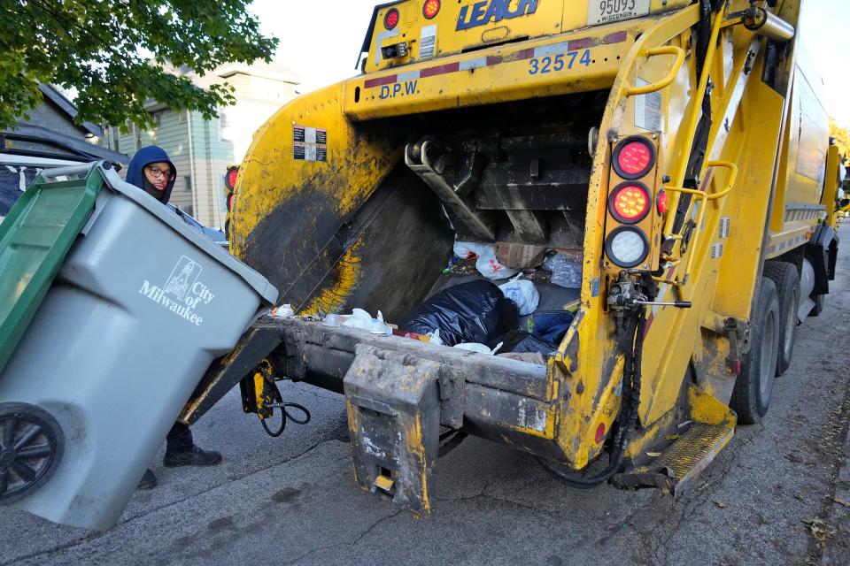 Amir Collins a Milwaukee Department of Public Works city laborer collects garbage on North 54th Street north of West Garfield Avenue in Milwaukee on Monday, Oct. 30, 2023