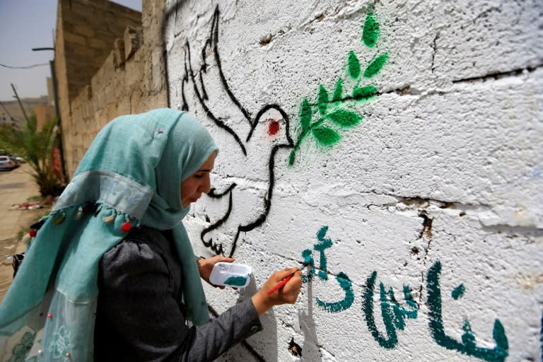 A Yemeni artist paints pro-peace graffiti on a wall in the capital Sanaa on August 16, 2018