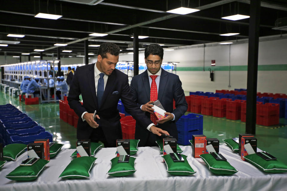 Sahir Berry, CEO of AfriOne, and Hemang Kapur, a director of AfriOne, prepare a display of AfriOne Gravity Z1 smartphones during a launch event in April 2017. (Photo: George Osodi/Bloomberg via Getty Images)