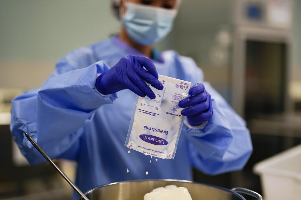 Milk lab technicians Welney Huang processes breast milk at the University of California Health Milk Bank, Friday, May 13, 2022, in San Diego. The U.S. baby formula shortage has sparked a surge of interest among moms who want to donate breast milk to help bridge the supply gap as well as those seeking to keep their babies fed. (AP Photo/Gregory Bull)