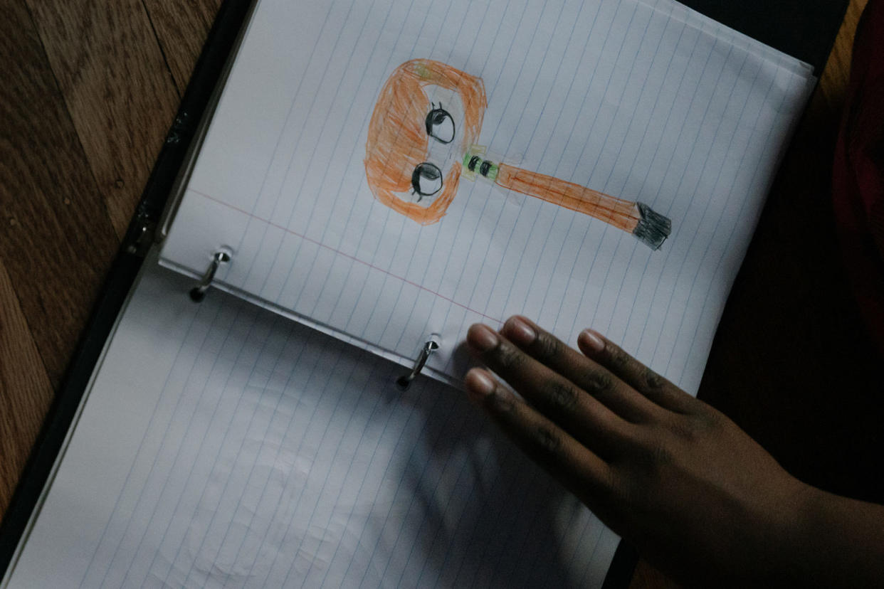 Image: Girl looking through a binder with drawings. (Caroline Gutman for NBC News)