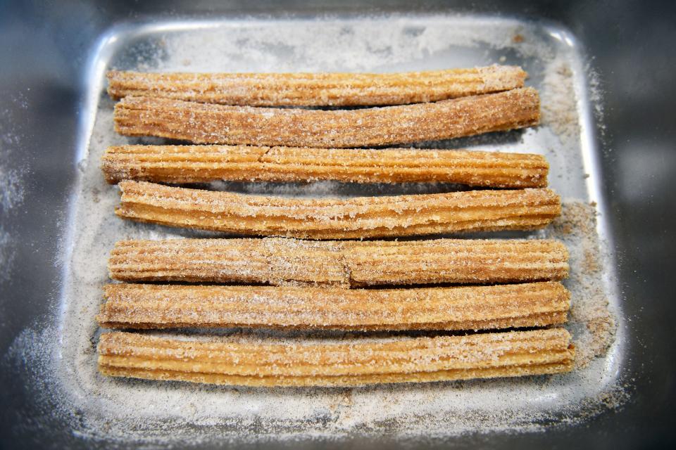 Caden Kennedy, supervisor at Donkey's Place Downtown in Mount Holly, prepares a batch of cinnamon-sugar churros, which were recently added to the menu. April 26, 2022.