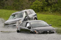 <p>Abandoned, damaged cars float on the side of I-75 in North Port, Florida, on Sept. 29.</p>