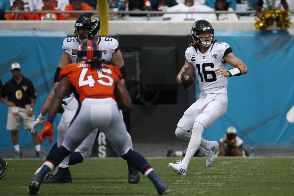 Jacksonville Jaguars quarterback Trevor Lawrence (16) looks for a receiver as Denver Broncos linebacker Alexander Johnson (45) rushes during the first half of an NFL football game, Sunday, Sept. 19, 2021, in Jacksonville, Fla. (AP Photo/Stephen B. Morton)