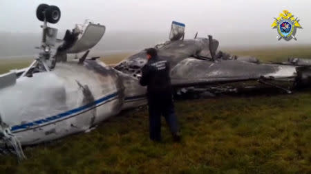 An investigator looks at the wreckage of Christophe de Margerie's Dassault Falcon jet at Moscow's Vnukovo airport in this still image taken from video, October 21, 2014. REUTERS/Russian Investigative Committee/Handout via Reuters TV