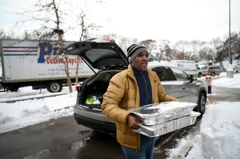 Abdirahman Kahin, owner of Afro Deli, donate food to residents of the Cedar Riverside, following a fire on the 14th floor of a public housing high-rise in Minneapolis on Wednesday, Nov. 27, 2019. Several people died and a few people were injured when the fire broke at the building in a heavily immigrant neighborhood of Minneapolis early Wednesday. (Aaron Lavinsky/Star Tribune via AP)