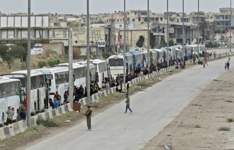 Hundreds of Syrian rebels and family members from the Eastern Ghouta town of Harasta board buses on March 23, 2018 for evacuation to rebel-held territory in the northwest