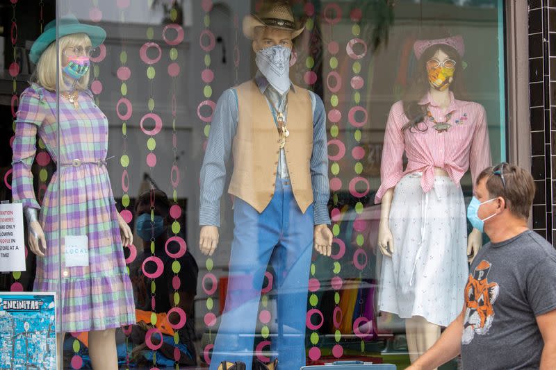 A man wears a mask as he walks through a retail shopping area during the outbreak of the coronavirus disease in California