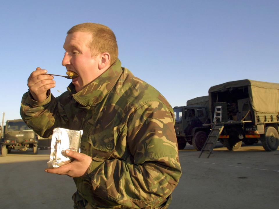 A British soldier eats his MRE in Afghanistan.