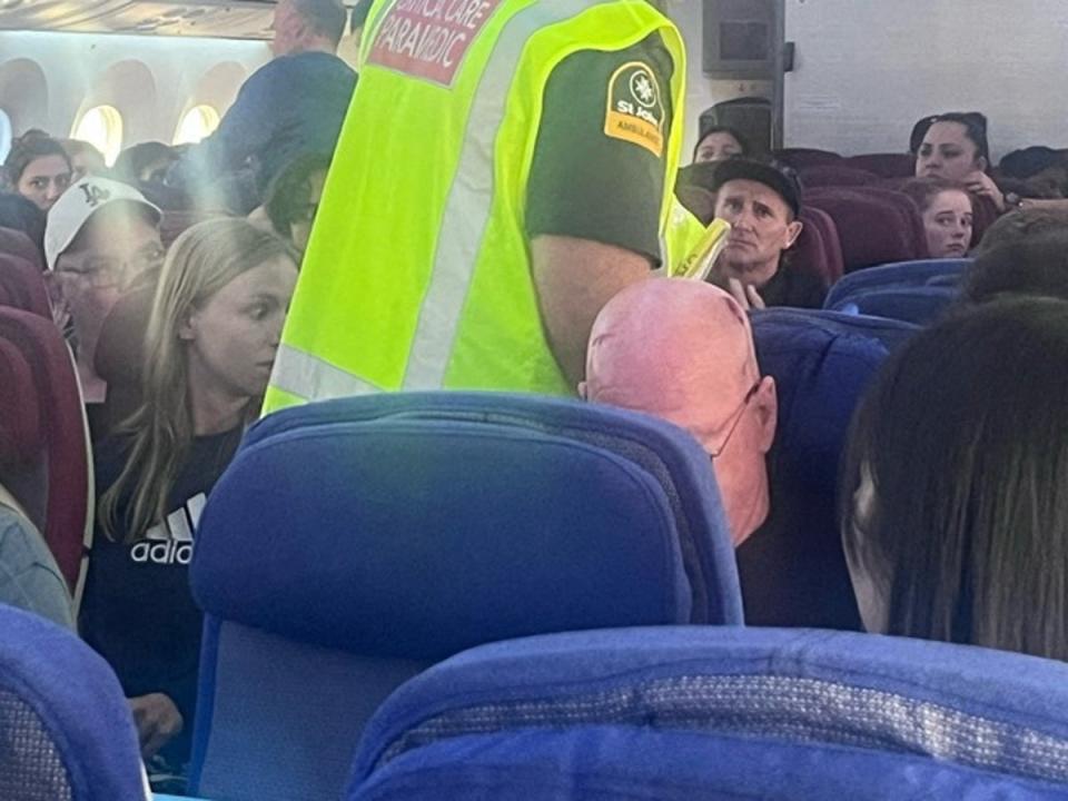 A paramedic walks onboard as passengers look on, after an incident on a LATAM Airlines Boeing 787, in Auckland (Brian Adam Jokat via REUTERS)