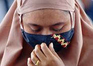 A family member of the passenger of Sriwijaya Air flight SJ 182, which crashed into the sea, mourns while visiting the site of the crash to pay their tribute, on the deck of Indonesia's Naval ship KRI Semarang, at the sea off the Jakarta coast