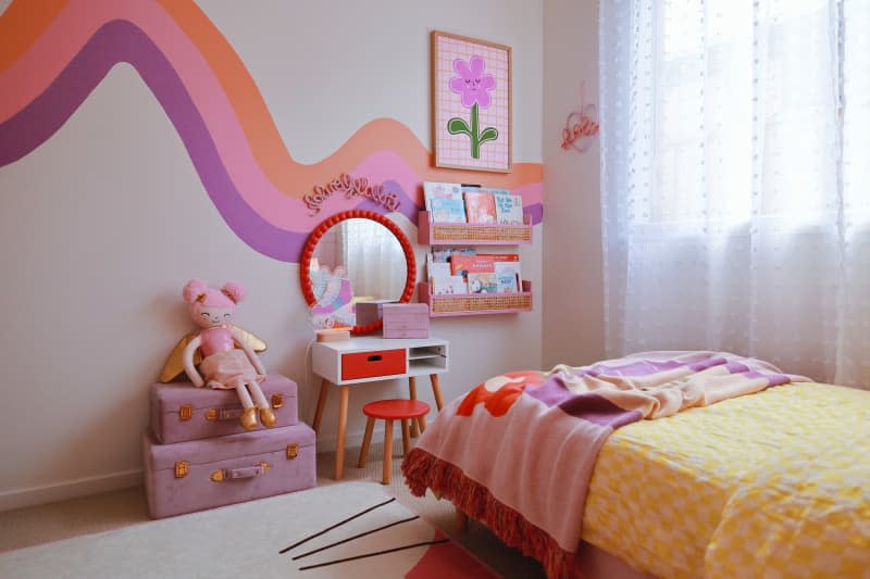 kids' room with wavy mural and pink, orange, purple, and yellow pops of color