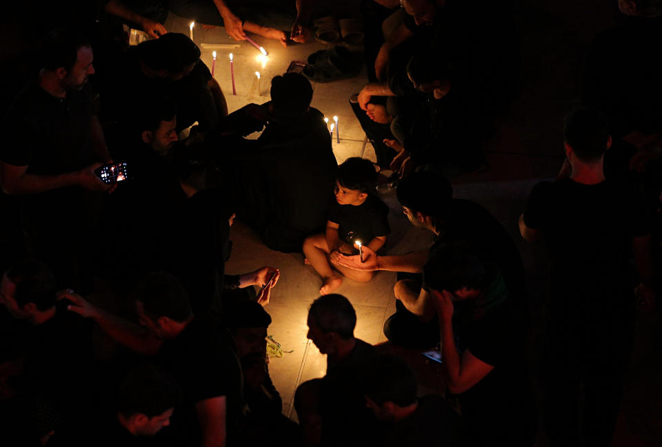 People pray for victims after a walkway collapsed and set off a stampede as thousands of Shiite Muslims marked one of the most solemn holy days of the year in the holy city of Karbala, Iraq, Tuesday, Sept. 10, 2019. Officials say at least 31 people have died and around 100 others were injured in the chaos Tuesday, which occurred toward the end of the Ashoura procession, causing panic and a stampede, according to two officials. (AP Photo/Anmar Khalil)