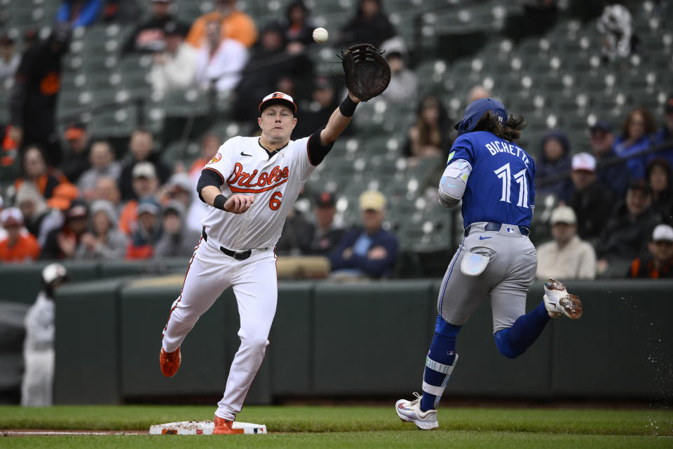 Baltimore Orioles first baseman Ryan Mountcastle (6) reaches for the throw as Toronto Blue Jays' Bo Bichette (11) is safe at first with a single during the second inning of a baseball game, Wednesday, May 15, 2024, in Baltimore. (AP Photo/Nick Wass)