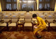An attendant cleans a carpet stain before the opening ceremony of the Asian Infrastructure Investment Bank (AIIB) in Beijing, China January 16, 2016. REUTERS/Mark Schiefelbein/Pool