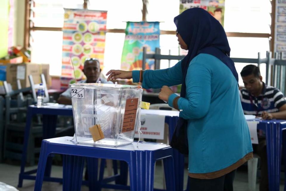 A voter casts her ballot at a polling station in Rantau April 13, 2019. ― Picture by Ahmad Zamzahuri