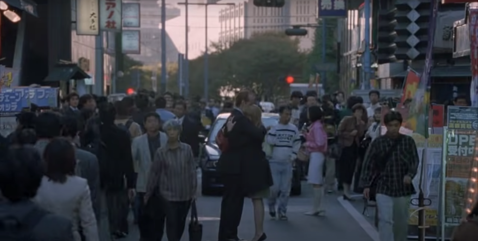 A man and a woman embrace in a crowd