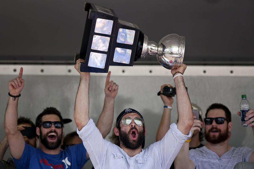 FILE - In this June 13, 2012, file photo, Norfolk Admirals captain Mike Angelidis lifts the Calder Cup over his head at Scope Plaza after the conclusion of the parade through downtown Norfolk, Va. Jon Cooper is one victory by his Tampa Bay Lightning away from becoming just the second coach in the NHL's salary-cap era to win the Stanley Cup in back-to-back seasons. Cooper also won the American Hockey League's Calder Cup in 2012 with Norfolk after going on a 28-game winning streak during the season. (Sean Proctor/The Virginian-Pilot via AP, File)