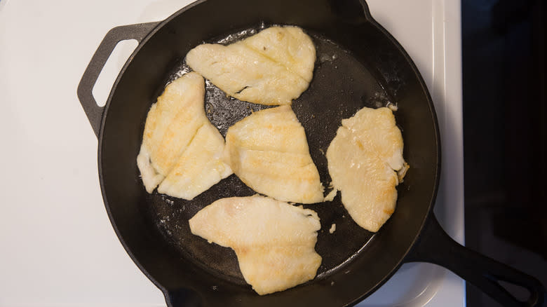 flounder frying in iron pan