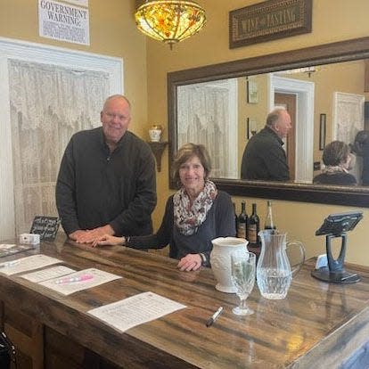 Barry and Denise Cavanaugh stand behind the bar in their wine tasting room at Raindrops on Roses Bed & Breakfast.