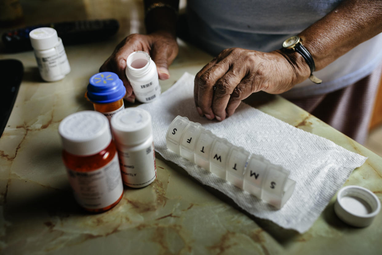 prescriptions  Close-up of senior black woman sorting weekly medication. Member of a black middle class America family.