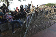 Student protesters try to bring down razor wire barricade set up by the police during a clash in Jakarta, Indonesia, Monday, Sept. 30, 2019. Thousands of Indonesian students resumed protests on Monday against a new law they say has crippled the country's anti-corruption agency, with some clashing with police. (AP Photo/Tatan Syuflana)