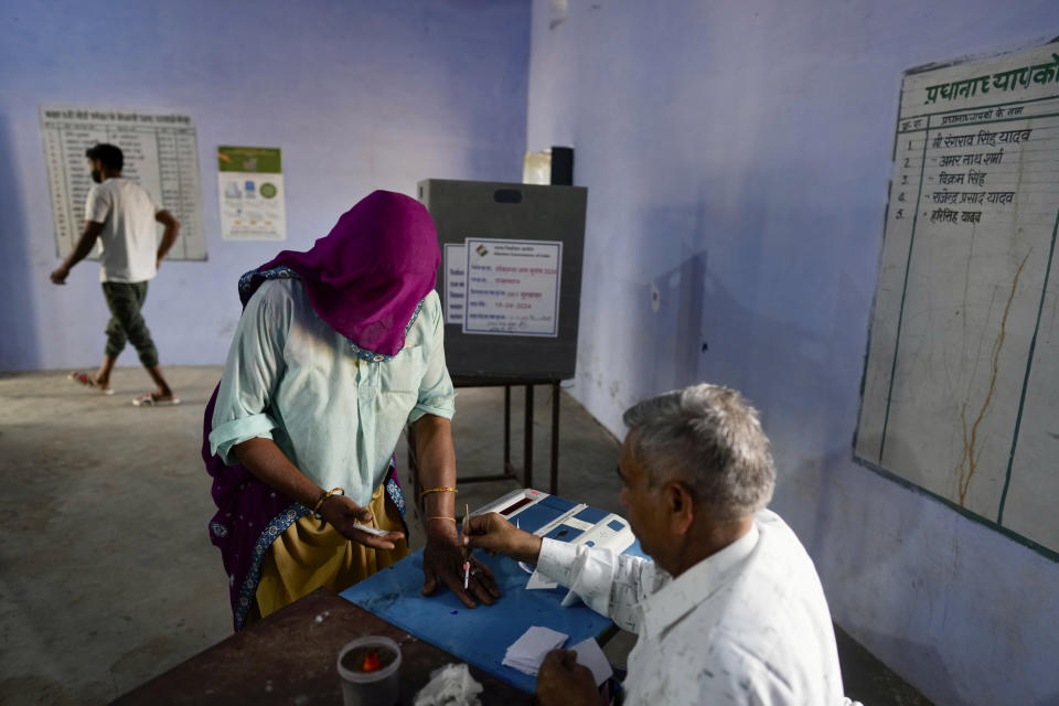 A woman prepares to vote during the first round of voting of India's national election in Neemrana, Rajasthan state, India, Friday, April 19, 2024. Nearly 970 million voters will elect 543 members for the lower house of Parliament for five years, during staggered elections that will run until June 1. (AP Photo/Manish Swarup)