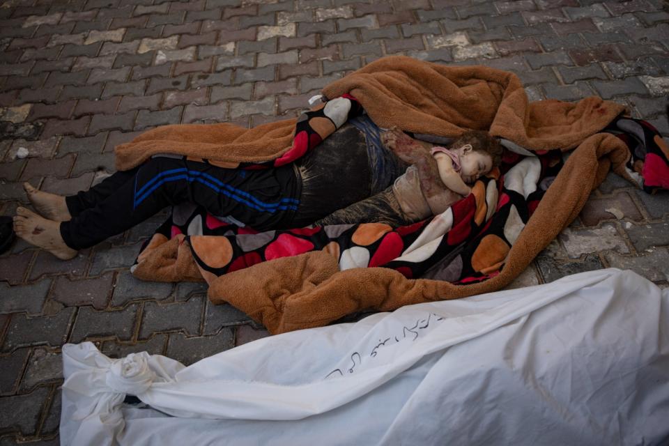 2023年10月22日，加薩走廊中部的迪爾巴拉（Deir al-Balah）遭轟炸後，一對父子的遺體放在毛毯上。美聯社