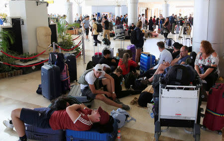 Foreign tourists sit and lie on the floor as they queue to leave Lombok Island after an earthquake hit, as seen at Lombok International Airport, Indonesia, August 6, 2018. REUTERS/Beawiharta