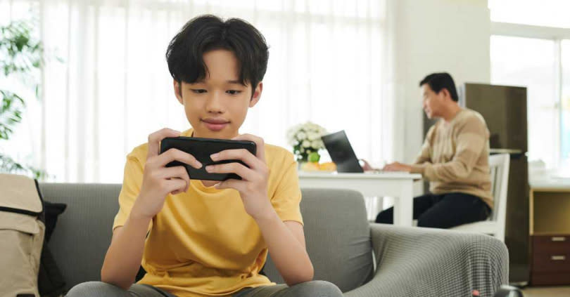 如果家長忙著工作，而孩子又不知如何安排生活時，玩手機是最方便快速的娛樂，也變得更容易沉迷。（圖／123RF）