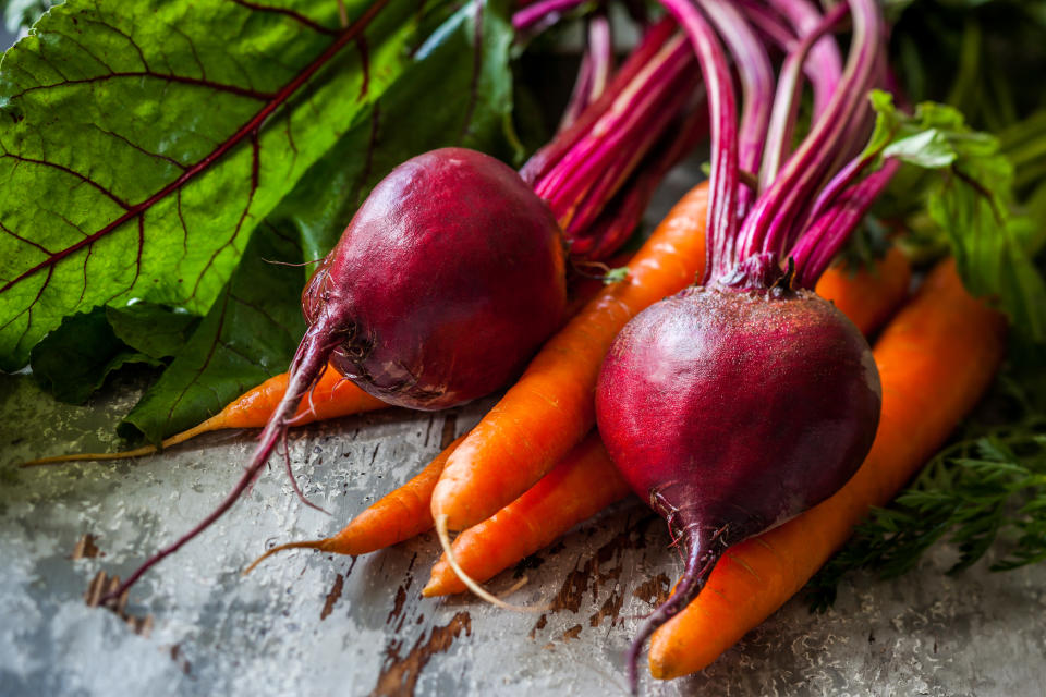 Fresh organic carrots and beetroot  on old wooden board