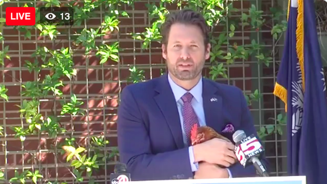 S.C. Democratic nominee for governor Joe Cunningham holds a live chicken on Thursday, Oct. 6, 2022, in Charleston as he criticizes Gov. Henry McMaster for only meeting for one debate.