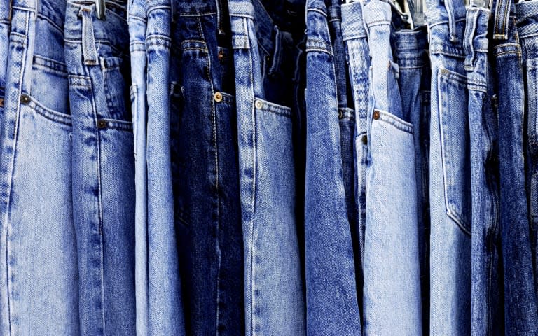 &#39;A rack of a variety of blue denim jeans in various shades of blue. Texture, patterns and variety.&#39;