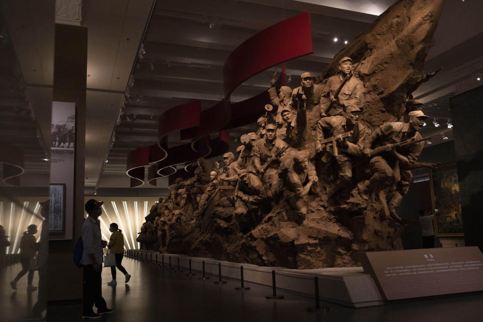 Visitors walk past a sculpture depicting Chinese soldiers at an exhibition that includes the War of Resistance against Japanese Aggression in Beijing on Thursday, Sept. 3, 2020. China on Thursday commemorated the 75th anniversary of the end of World War II in the Pacific, during which it endured a brutal invasion and occupation of much of its territory by Japan. (AP Photo/Ng Han Guan)