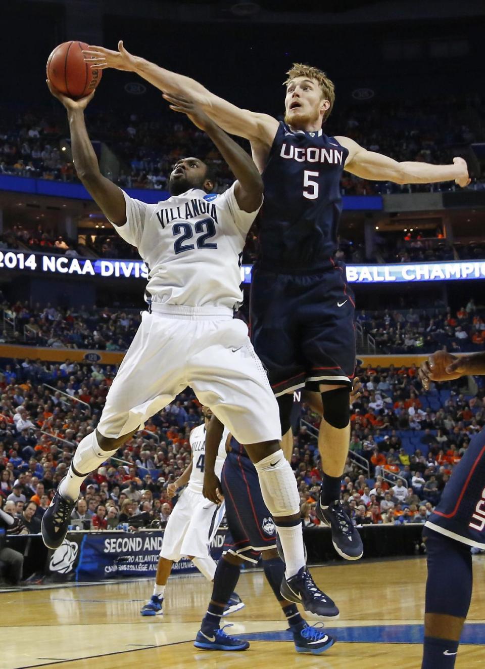 Villanova's JayVaughn Pinkston (22) drives past Connecticut's Niels Giffey (5) during the first half of a third-round game in the NCAA men's college basketball tournament in Buffalo, N.Y., Saturday, March 22, 2014. (AP Photo/Bill Wippert)