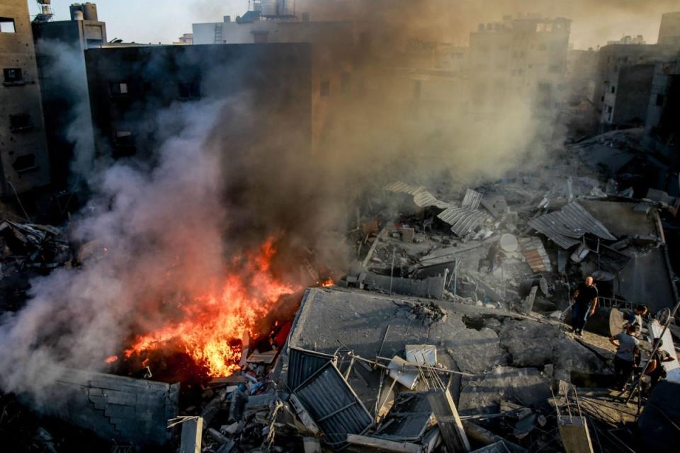 Palestinians stand on the rubble of a levelled building in Gaza City on Thursday (AFP via Getty Images)