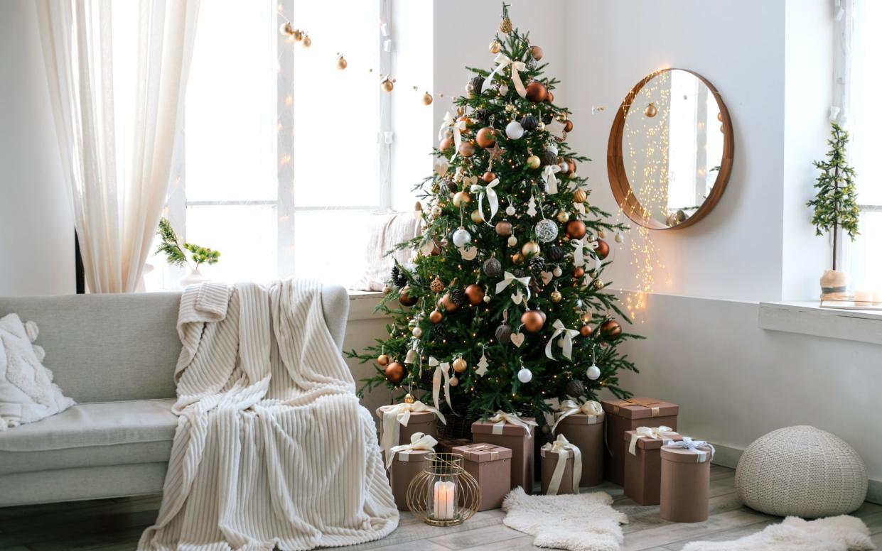 Christmas tree decorating in home with presenr boxes near it. Copy space - Evgeniia Siiankovskaia