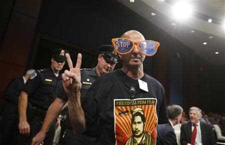 A protester against U.S. spy agency practices is escorted by Capitol Police from a hearing room where U.S. Director of National Intelligence James Clapper testified at a House Intelligence Committee hearing on Capitol Hill in Washington, October 29, 2013. REUTERS/Jason Reed