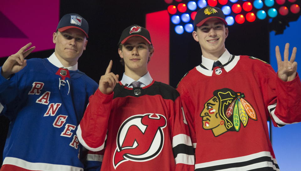 New York Rangers draft pick Kaapo Kakko, left; New Jersey Devils pick Jack Hughes, center; and Chicago Blackhawks pick Kirby Dach pose for photos during the first round of the NHL hockey draft Friday, June 21, 2019, in Vancouver, British Columbia. (Jonathan Hayward/The Canadian Press via AP)