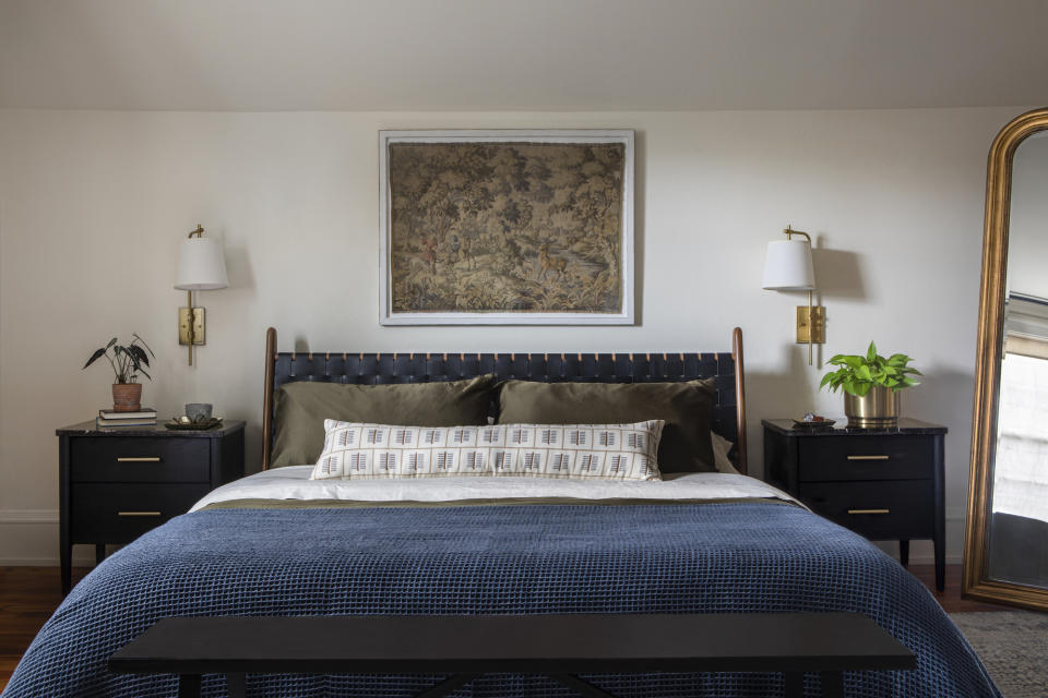 A well lit bedroom with sconces either side of the bed