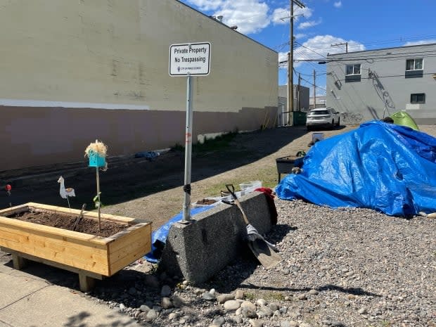 Community members have set up planter boxes on an empty city lot often used as a campsite for people without homes in Prince George, B.C. The city says it will serve notices of trespass to people on the site starting June 11. (Andrew Kurjata/CBC - image credit)