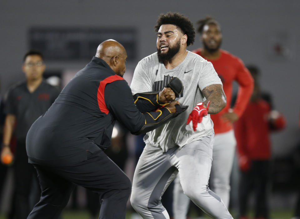 FILE - Defensive tackle Haskell Garrett, right, runs a drill during Ohio State football pro day in Columbus, Ohio, March 23, 2022. Josh Paschal and Garrett count themselves among the lucky ones. They understand only a tiny fraction of football players get a chance to play in the NFL, and even fewer overcome frightening experiences like theirs to become legitimate draft prospects. (AP Photo/Paul Vernon, File)