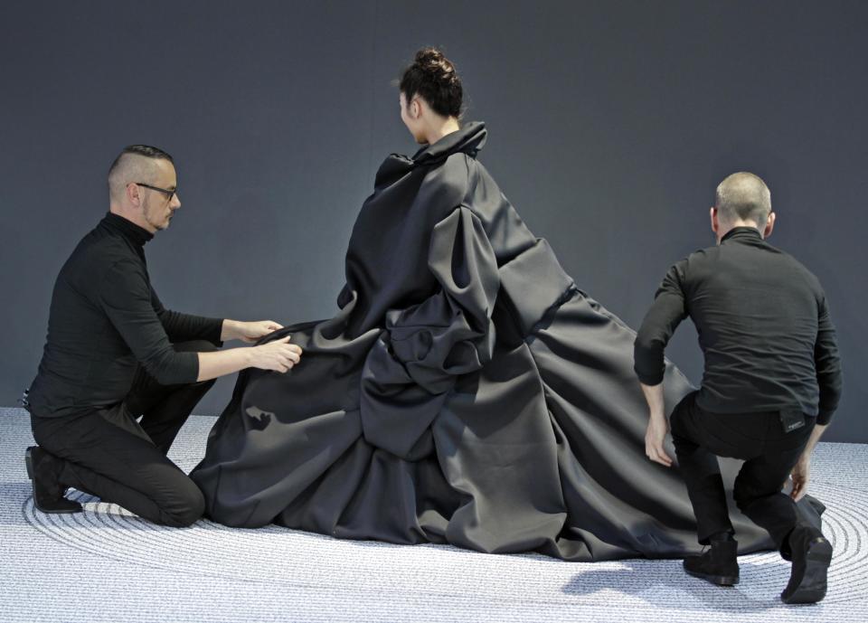 Dutch fashion designers Viktor Horsting, left, and Rolf Snoeren, right, adjust their creation worn by a model, as part of Viktor and Rolf 's Haute Couture Fall-Winter 2013-2014 collection, presented Wednesday, July 3, 2013 in Paris.(AP Photo/Remy de la Mauviniere)