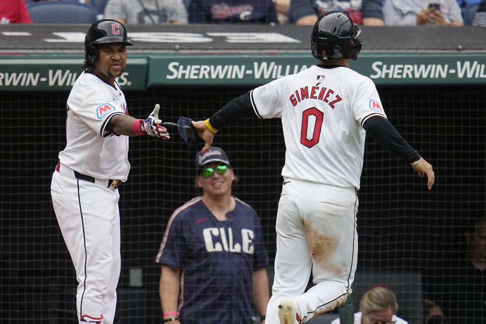 Cleveland Guardians' Andrés Giménez (0) is congratulated by teammate José Ramírez, left, after scoring on a walk by Steven Kwan in the fifth inning of a baseball game against the Chicago White Sox, Thursday, July 4, 2024, in Cleveland. (AP Photo/Sue Ogrocki)