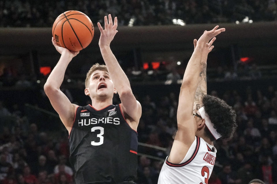 UConn guard Joey Calcaterra, left, drives to the basket against St. John's guard Andre Curbelo, during the first half of an NCAA college basketball game, Saturday, Feb. 25, 2023, in New York. (AP Photo/Bebeto Matthews)