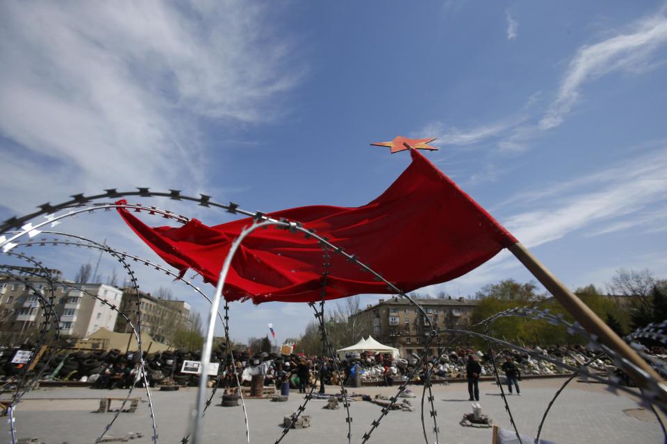 A flag flutters in the wind over barricades at the regional administration building that has been seized earlier in Donetsk, Ukraine, Friday, April 18, 2014. Pro-Russian insurgents in Ukraine’s east who have been occupying government buildings in more than 10 cities said Friday they will only leave them if the interim government in Kiev resigns.(AP Photo/Sergei Grits)